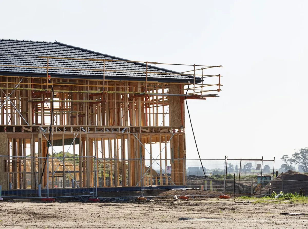 Roof Replacement in East Orange — a two-story house frame with its roof covered and scaffolding in place
